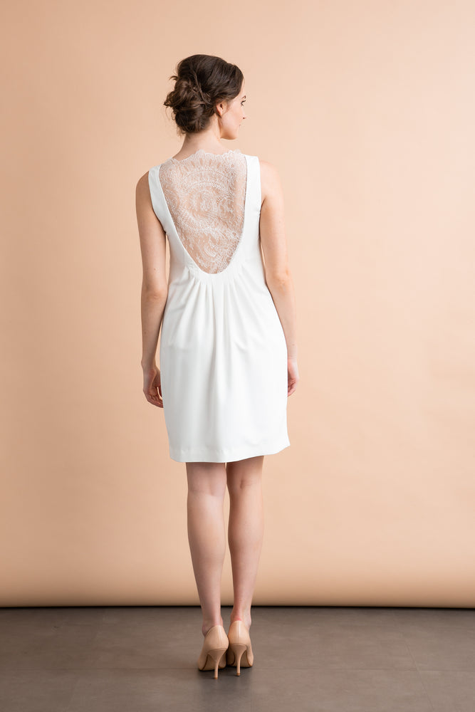 
                  
                    a woman in a white dress standing in a room 
                  
                