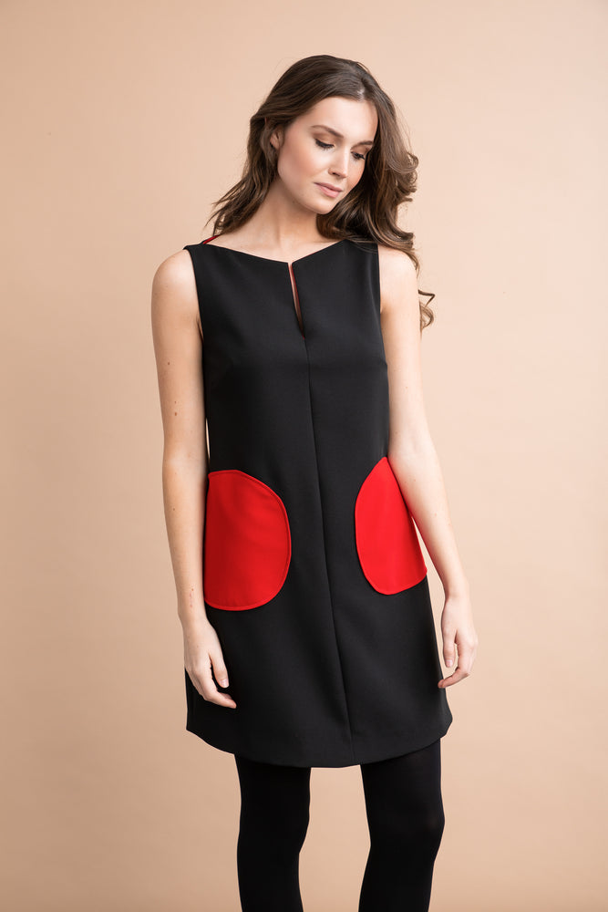 
                  
                    a woman in a black dress holding a purse 
                  
                