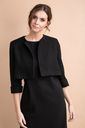 
                  
                    a woman standing in front of a wall wearing a suit 
                  
                