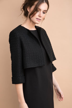 
                  
                    a woman in a suit and tie standing next to a wall 
                  
                